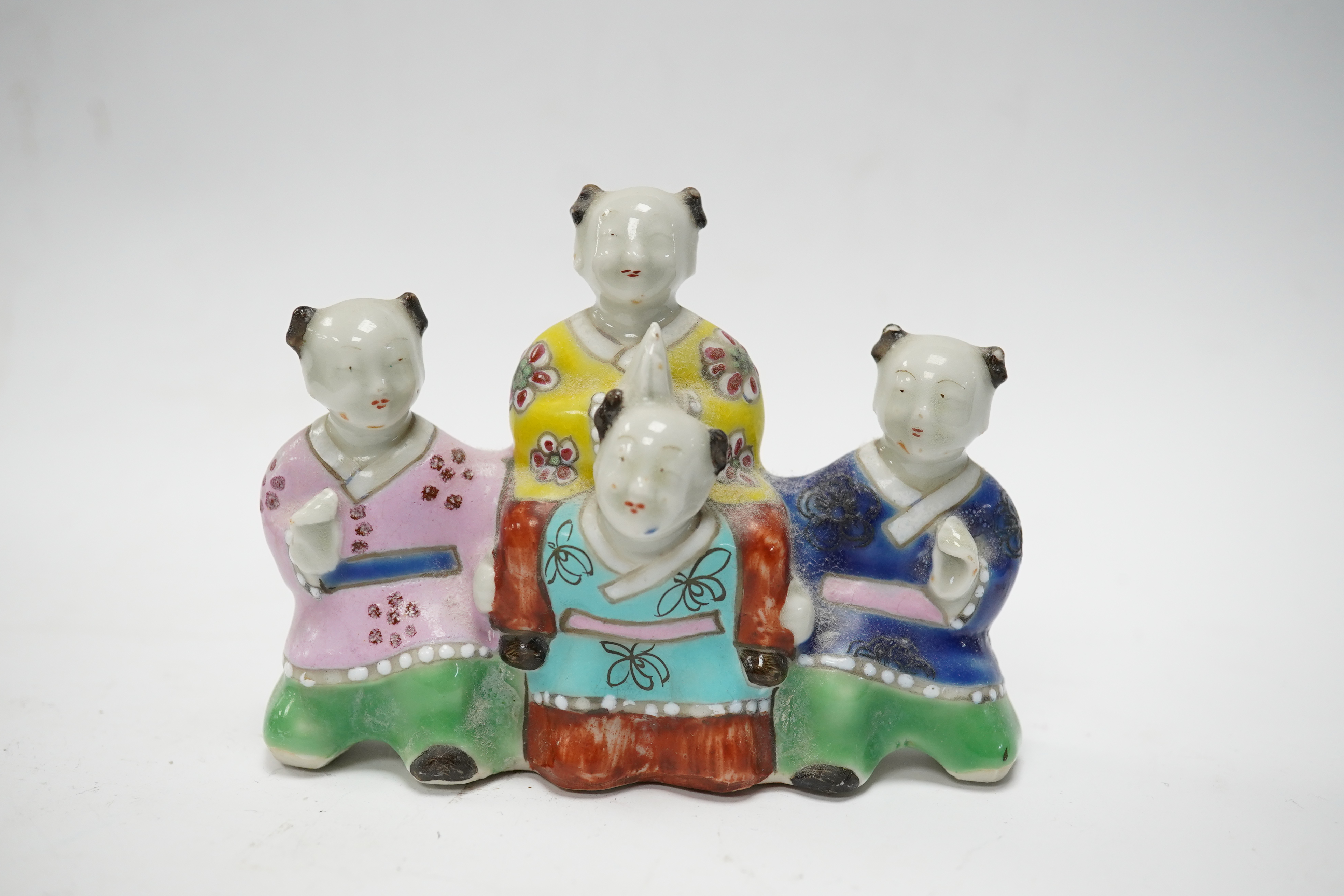 A Chinese enamelled porcelain ‘boys’ brush rest, early 19th century, 10.5cm wide. Condition - fair